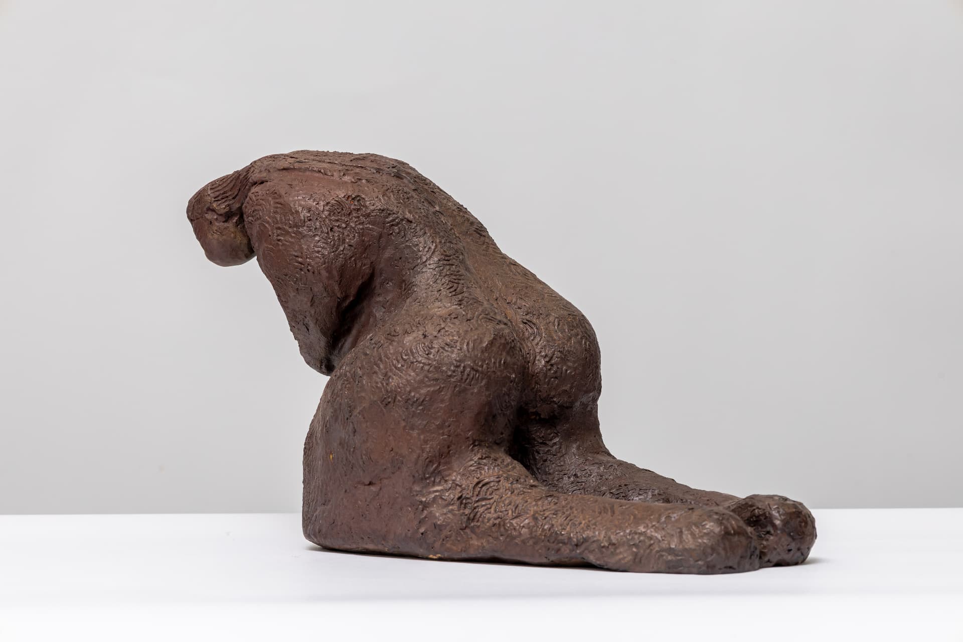 Grief, reclining bronze figure in profile