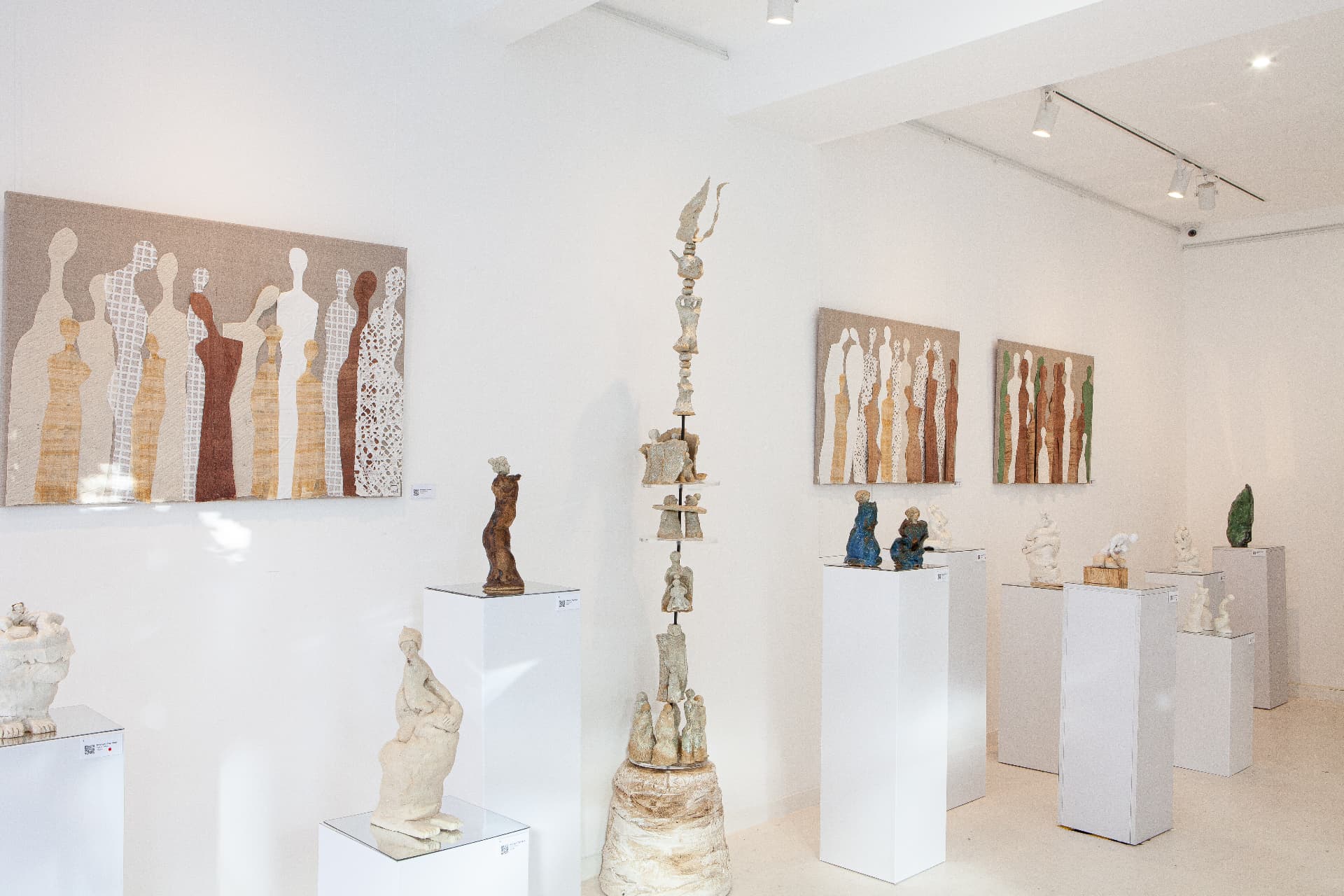 Wide installation view including a tall stacked ceramic totem