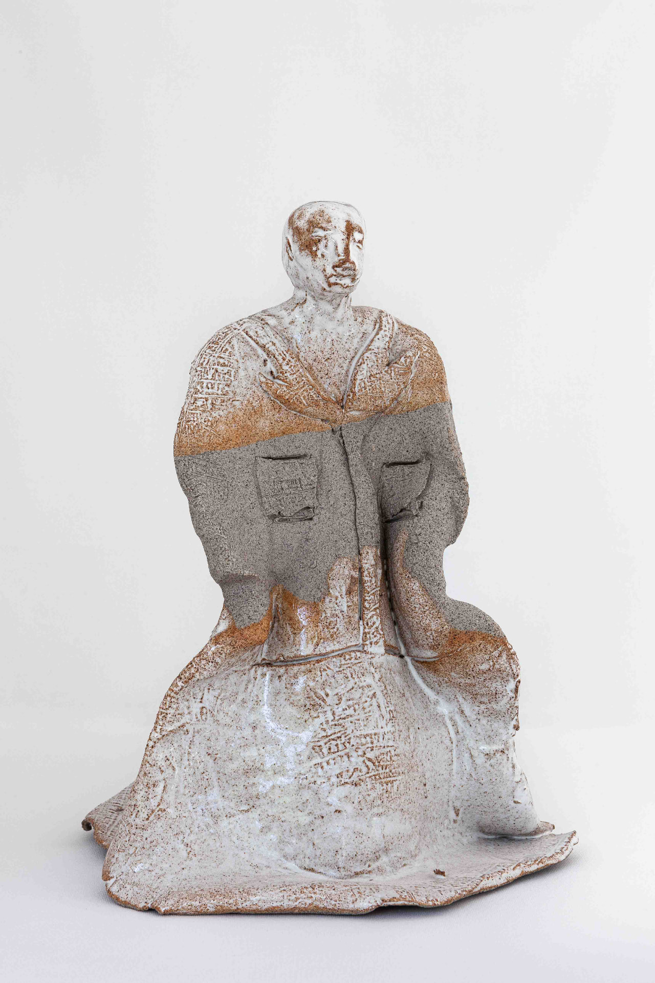 Seated glazed ceramic figure with incised surface