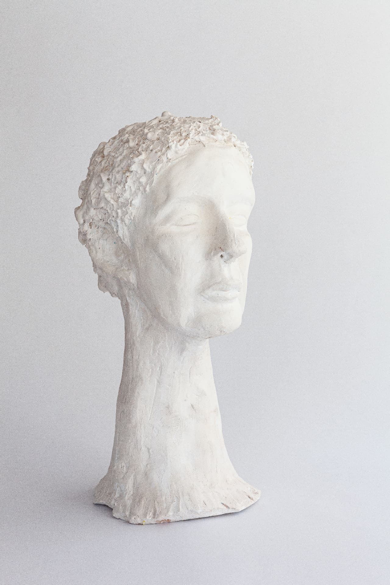 White plaster head of a woman with a long elegant neck, front view